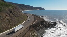 2023 - Excellent Aerial Footage Of Cars And Trucks Driving Along The Coast Of Point Mugu, California As Waves Hit The Shore.