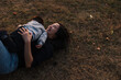 © Rob and Julia Campbell/Stocksy - Mom and child rolling and playing in the grass outside.