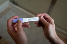 Woman Holding A Positive Pregnancy Test In Her Hands