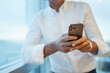 © Daniel Gonzalez/Stocksy - Crop businessman checking messages on smartphone