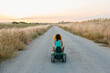 © Jimena Roquero/Stocksy - Back of Kid riding a toy tractor on countryside road at sunset