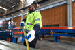 © chachamp - Portrait African American engineer man checking metal with tape measure at metal sheet factory