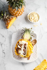 Wall Mural - yogurt with granola and pineapple on a light background
