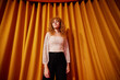 © Javier Díez/Stocksy - Stylish young woman standing near curtain