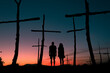 © Ibai Acevedo/Stocksy - Couple silhouette at surreal wood crosses field