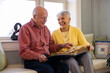 © Raymond Forbes LLC/Stocksy - Senior Citizen couple at home Looking at photo album