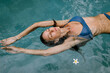 © Julia Volk/Stocksy - Woman Relaxing In Swimming Pool