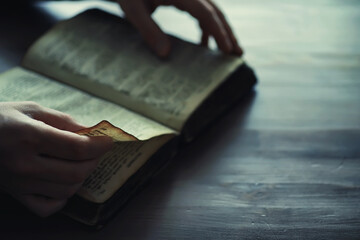 Wall Mural - Reading religious literature. A man studies the Koran and sorts out the rosary.