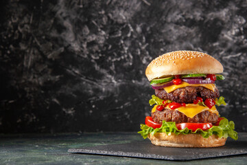 delicious homemade burger of beef, cheese and vegetables on an table. fat unhealthy food close-up, b