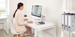 © Studio Romantic - Side view portrait of a concentrated young business woman accountant sitting at the desk and working on a laptop with tables and charts at office or at home and looking to the monitor screen. Banner.