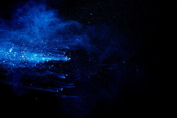 Wall Mural - Blue  color powder explosion cloud on black background. Closeup of Blue  dust particles splash.