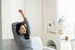 © PaeGAG - Young beautiful peaceful Asian woman leaning and stretching herself on comfortable sofa.