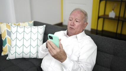 Sticker - senior using smartphone with worried expression at home