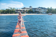 A Sexy Woman In A Sexy Plaid Bikini Standing On On Floating Pontoon Near A Luxurious Resort. Lifestyle And Recreation. In Panglao Island, Bohol.