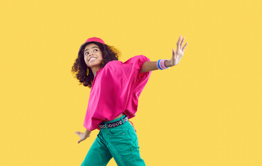 happy child dancing. cheerful little african american girl wearing loose oversized fuschia top and g