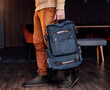 © VlaDee - man holding in hand canvas backpack