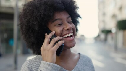 Canvas Print - African american woman smiling confident talking on the smartphone at street