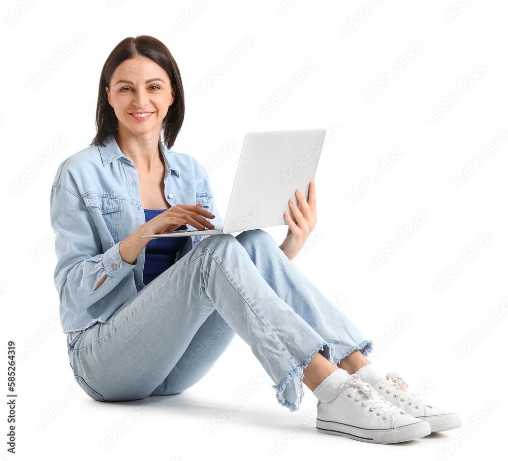 Pretty young woman with laptop sitting against white background