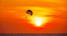 Silhouette Travel People Parasailing Over Sea Against Sky During Sunset In Golden Hour Of Sunset Or Sunrise Sky,Active And Extreme Recreation