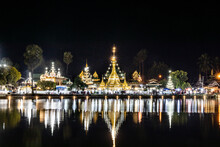 Well Lighted Wat Chong Kham In Mae Hong Son Thailand At Night, With Reflection From The Lake