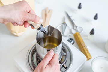 Woman making decorative aroma candle adding aroma, closeup