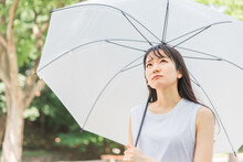 梅雨に傘を差すアジア人女性(困る)
