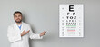 Vision test. Ophthalmologist or optometrist pointing at eye chart on light grey wall, banner design