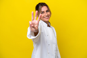 Sticker - Uruguayan chef woman isolated on yellow background happy and counting three with fingers