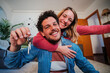 © Jose Calsina - Young caucasian couple showing keys of their first house after purchase and moving to new home together. happy husband and wife hugging in their apartment excited to be owners of a apartment. High