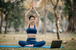 © Nuttapong punna - Portrait of young woman with closed eyes sitting in lotus position on yoga mat in the garden. sun light