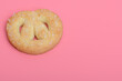 Kruche słodkie ciasteczko posypane cukrem leżące na różowym tle