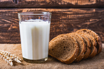 Wall Mural - A glass with milk and bread on the table