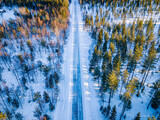 Fototapeta Natura - Winter in Finland. Road in forest.