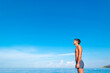 © jana_janina - The figure of a young tanned guy on the beach against the background of the blue sea and sky.