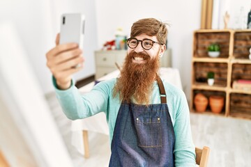 Sticker - Young redhead man make selfie by the smartphone drawing at art studio