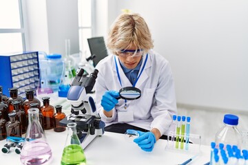 Poster - Young blond man scientist using magnifying glass at laboratory