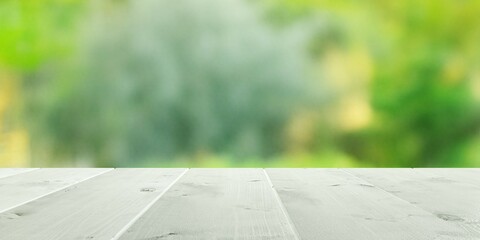 Wall Mural - Empty white wooden table top with out of focus lights bokeh green garden background with bushes and trees