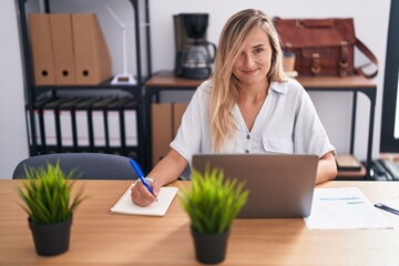 Canvas Print - Young blonde woman business worker using laptop writing on document at office