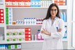 © Krakenimages.com - Young hispanic girl pharmacist standing with arms crossed gesture at pharmacy