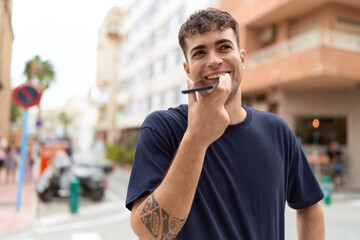 Canvas Print - Young hispanic man smiling confident talking on the smartphone at street