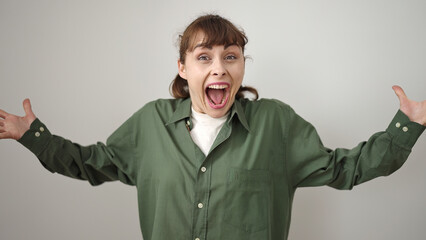 Poster - Young caucasian woman standing with surprise expression and raised arms over isolated white background