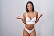 © Krakenimages.com - Hispanic woman wearing lingerie smiling cheerful with open arms as friendly welcome, positive and confident greetings