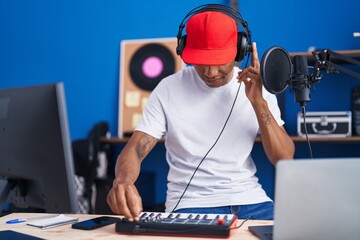 Poster - Young latin man musician having dj session at music studio