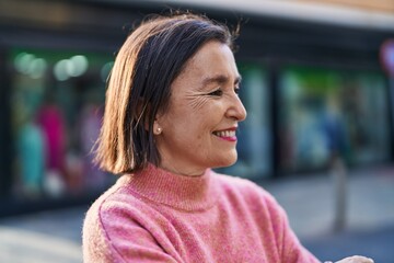 Wall Mural - Middle age woman smiling confident standing at street