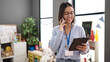 © Krakenimages.com - Young beautiful hispanic woman working as a teacher talking on smartphone using touchpad at kindergarten