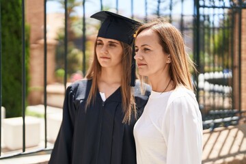 Wall Mural - Two women mother and graduated daughter standing together at campus university