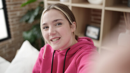 Sticker - Young blonde woman make selfie by camera sitting on bed at bedroom