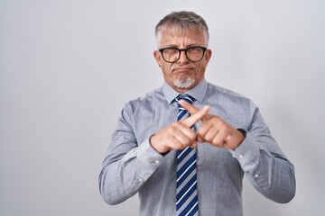 Poster - Hispanic business man with grey hair wearing glasses rejection expression crossing fingers doing negative sign