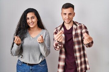 Sticker - Young hispanic couple standing over white background doing money gesture with hands, asking for salary payment, millionaire business