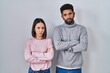 © Krakenimages.com - Young hispanic couple standing together skeptic and nervous, disapproving expression on face with crossed arms. negative person.